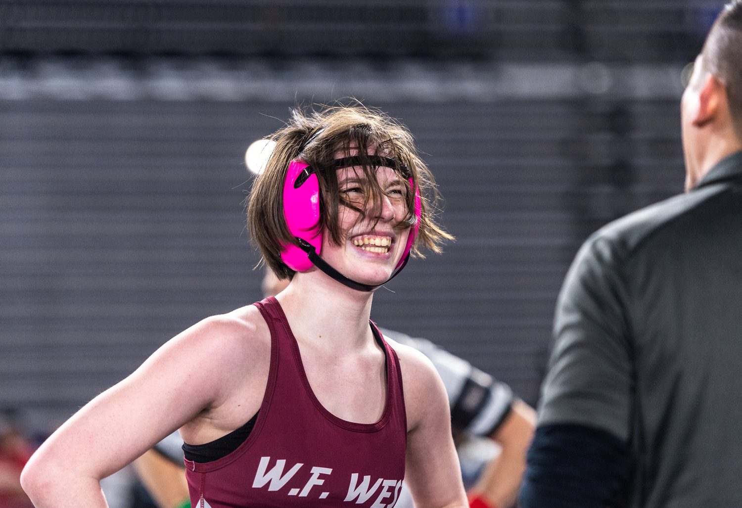 W.F. West’s Shelby Hazlett, 125 pounds, smiles as she talks with her coaches during an injury timeout at Mat Classic XXXIV on Friday, February 17, 2023, at the Tacoma Dome. (Joshua Hart/For The Chronicle)